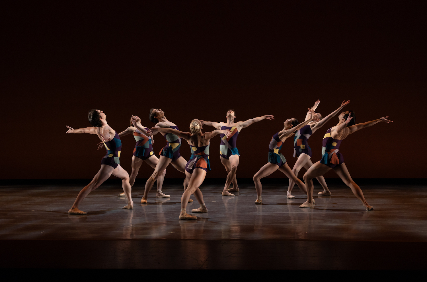 Eight ballet dancers performing on stage.