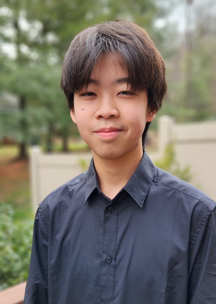 A smiling Matthew Keng wearing a black shirt outside