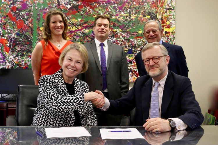 PSO Board Chair Yvonne Marcuse and Princeton Festival Board Chair Benedikt von Schroder shake hands and smile at the camera while incoming PSO board chair Stephanie Wedeking, PSO Executive Director Marc Uys, and former Princeton Festival board chair Costa Papastephanou stand behind them.