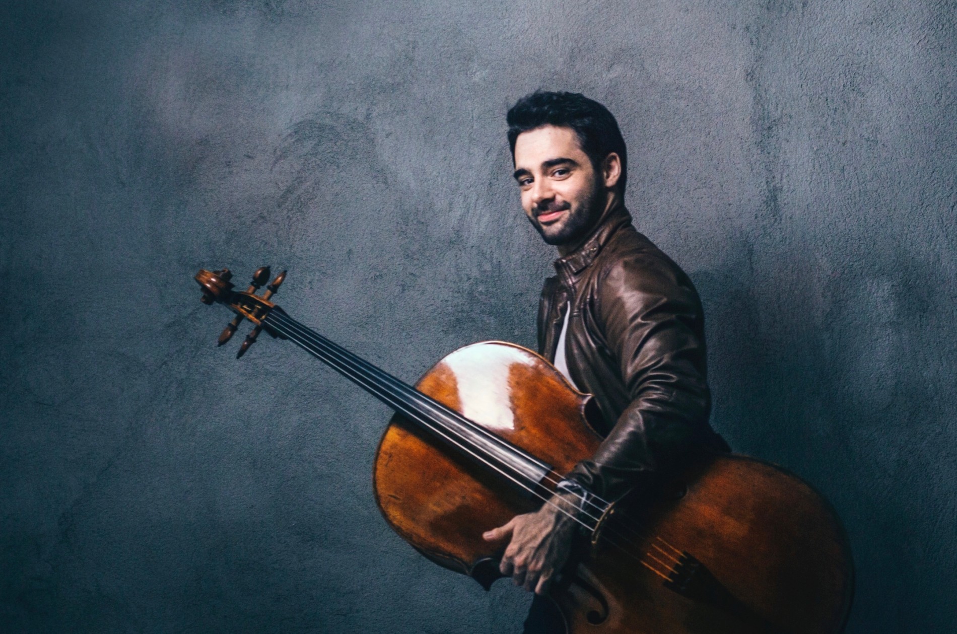 Pablo Ferrández, cellist, holding his instrument in left hand