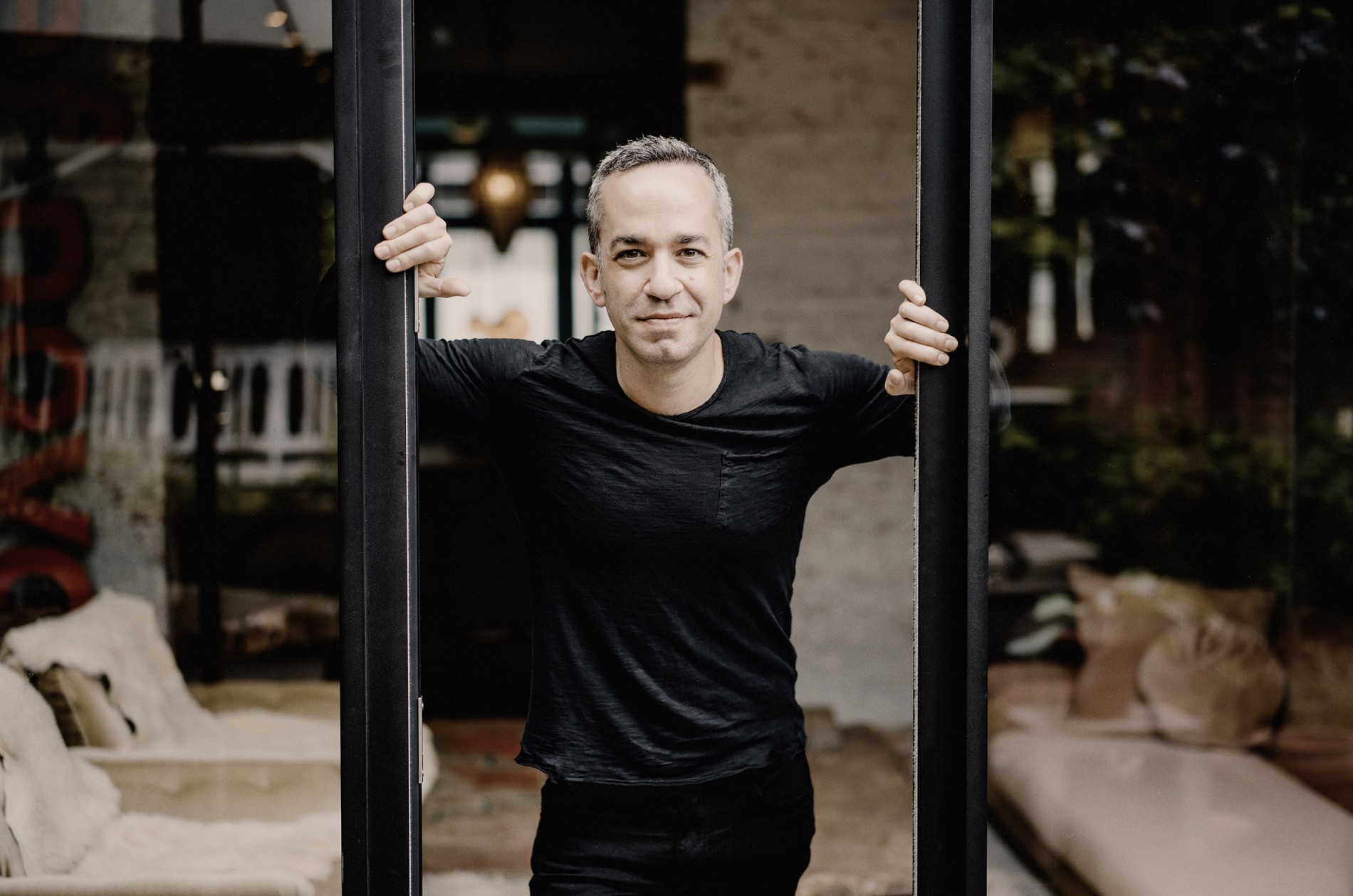 Inon Barnatan, pianist, standing at an open sliding door