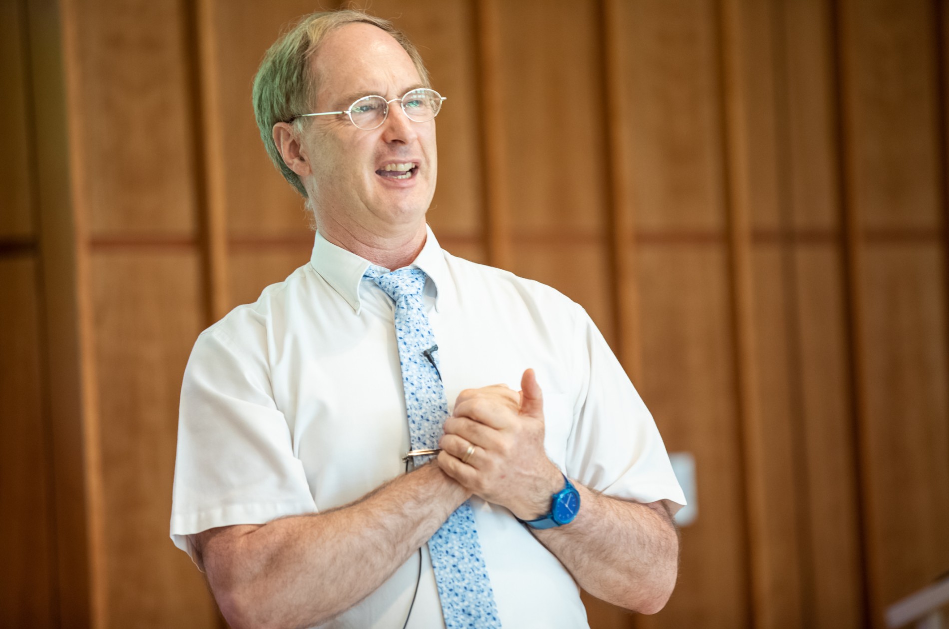 Timothy Urban - person in tie and shirt with hands clasped giving a talk