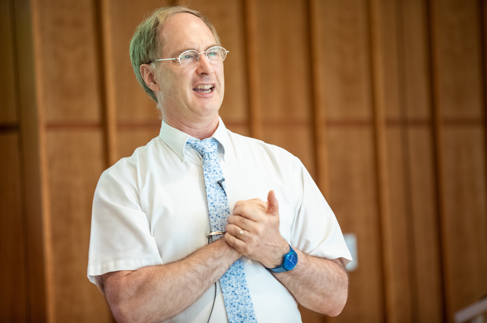 Timothy Urban - person in tie and shirt with hands clasped giving a talk